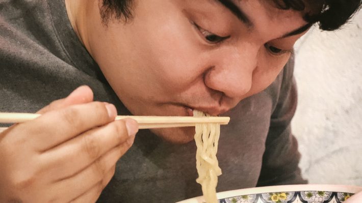 ラーメンにがっつく男性