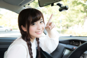 ドライブレコーダーを指差す可愛い彼女